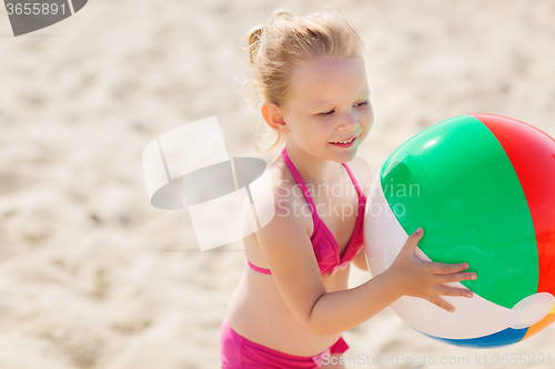 Image of happy little girl playing inflatable ball on beach