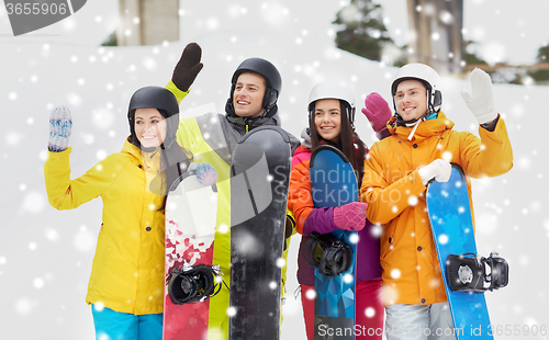 Image of happy friends in helmets with snowboards