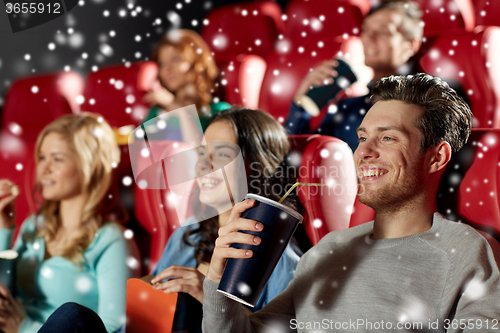 Image of happy friends with popcorn and drinks in cinema