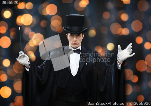 Image of magician in top hat showing trick with magic wand