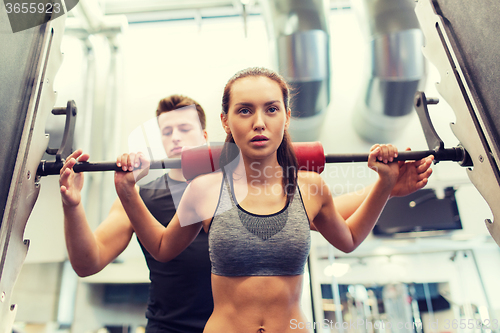 Image of man and woman with barbell flexing muscles in gym