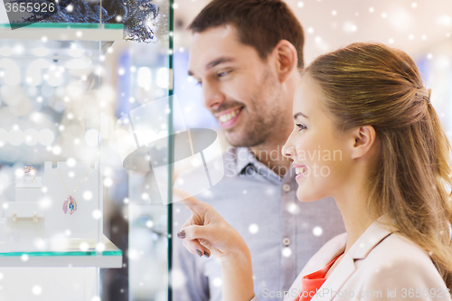 Image of couple looking to shopping window at jewelry store