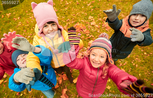 Image of happy children waving hands in autumn park
