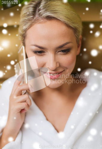 Image of beautiful young woman with smartphone at spa