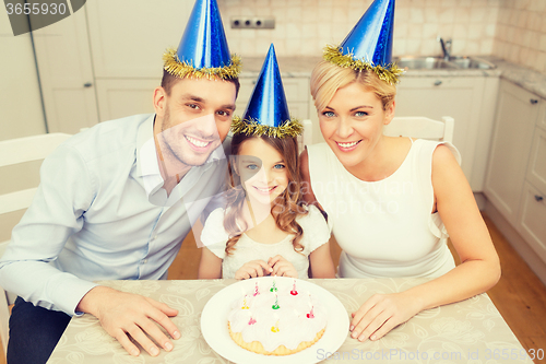 Image of smiling family in blue hats with cake