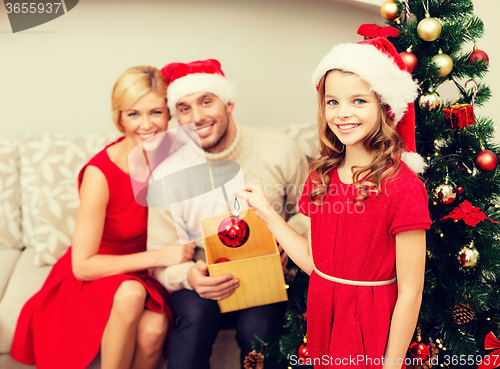 Image of smiling family decorating christmas tree