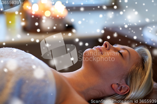 Image of close up of smiling young woman lying in spa salon
