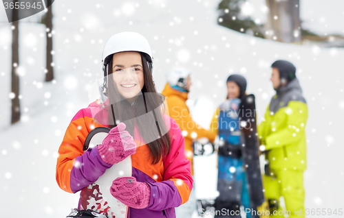 Image of happy friends in helmets with snowboards