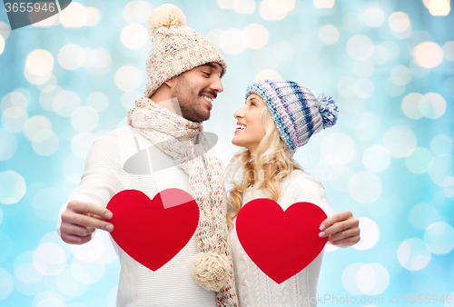 Image of smiling couple in winter clothes with red hearts