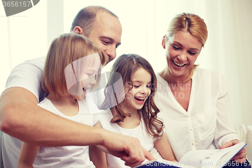 Image of happy family with book at home