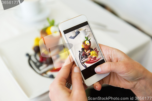 Image of close up of woman picturing food by smartphone