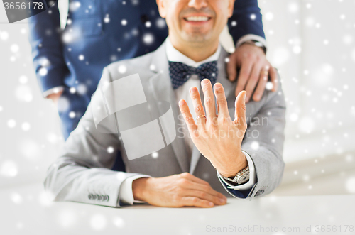 Image of close up of male gay couple with wedding rings on