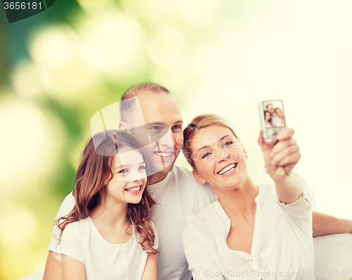 Image of happy family with camera at home