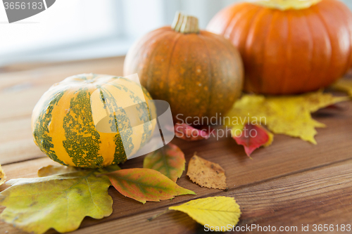 Image of close up of pumpkins on wooden table at home