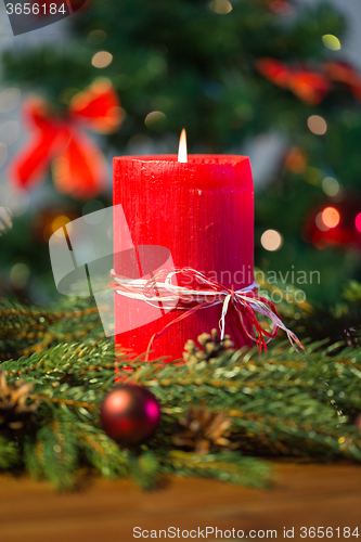 Image of fir branch wreath with candle on wooden table