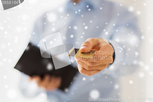 Image of close up of man holding wallet and credit card