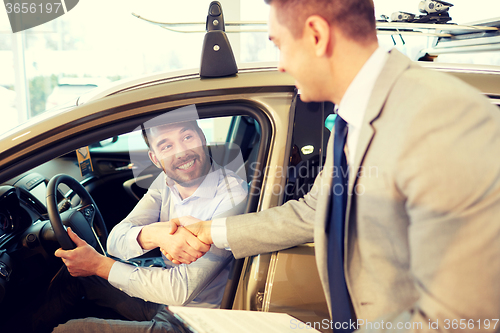 Image of happy man with car dealer in auto show or salon