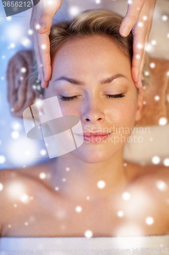 Image of close up of woman having face massage in spa salon