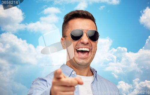 Image of laughing man in sunglasses pointing finger on you