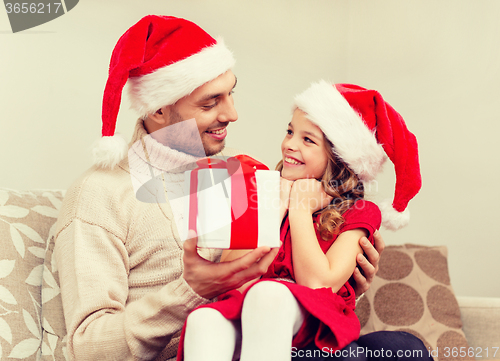 Image of smiling father giving daughter gift box