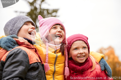 Image of group of happy children hugging in autumn park