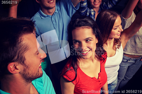 Image of smiling friends at concert in club