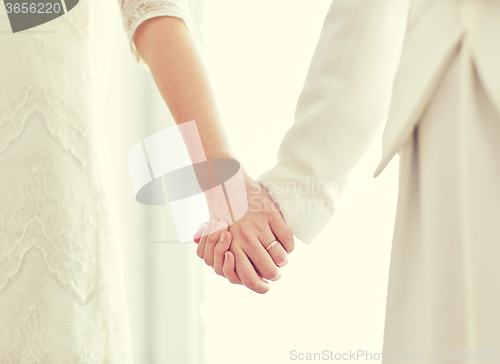 Image of close up of happy married lesbian couple hugging