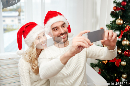 Image of couple taking selfie with smartphone at christmas