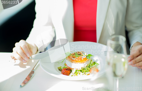 Image of close up of woman eating salad at restaurant