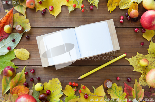 Image of empty note book with pencil and autumn leaves