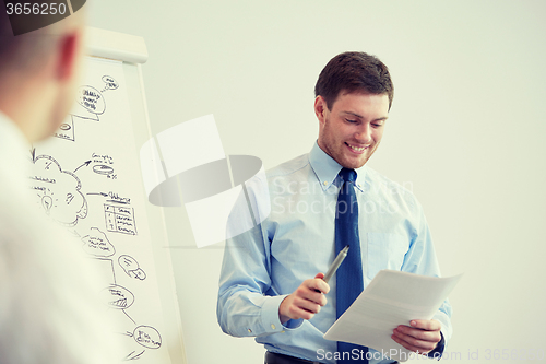 Image of group of smiling businessmen meeting in office