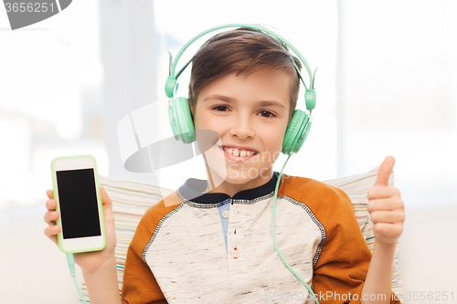 Image of happy boy with smartphone and headphones at home