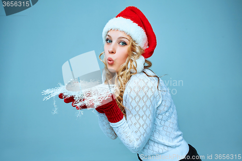 Image of Beautiful young woman in Santa Claus clothes with snowflakes