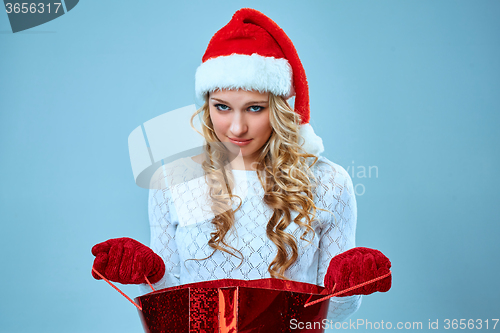 Image of Frustrated and annoyed beautiful young woman in Santa Claus hat