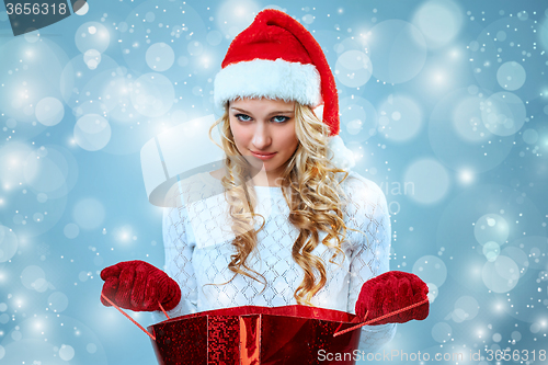 Image of Frustrated and annoyed beautiful young woman in Santa Claus hat