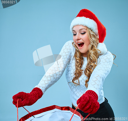 Image of Beautiful young woman in Santa Claus clothes