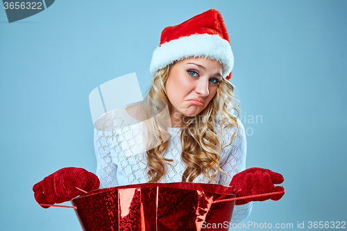 Image of Frustrated and annoyed beautiful young woman in Santa Claus hat