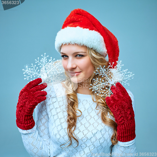 Image of Beautiful young woman in Santa Claus clothes with snowflakes