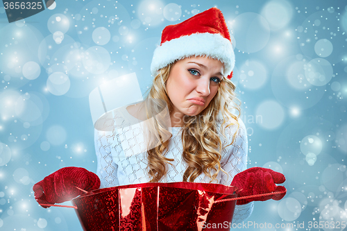 Image of Frustrated and annoyed beautiful young woman in Santa Claus hat
