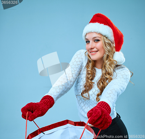 Image of Beautiful young woman in Santa Claus clothes