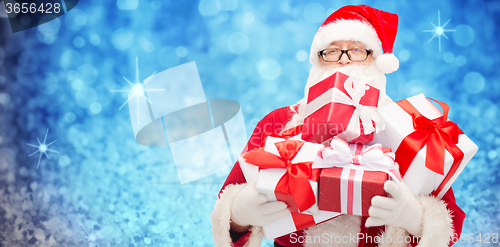 Image of man in costume of santa claus with gift boxes