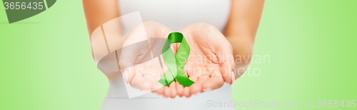 Image of close up of hands holding green awareness ribbon