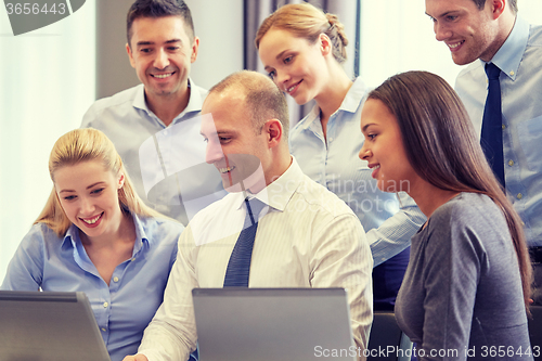 Image of smiling business people with laptop computer