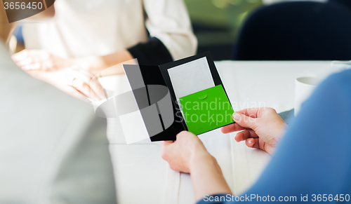 Image of close up of woman hands holding restaurant bill