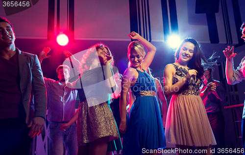 Image of smiling friends dancing in club