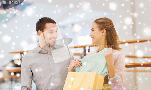 Image of happy young couple with shopping bags in mall