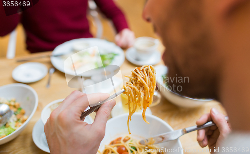 Image of close up man eating pasta for dinner at restaurant