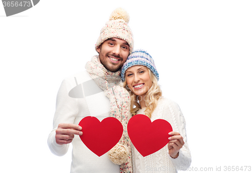 Image of smiling couple in winter clothes with red hearts