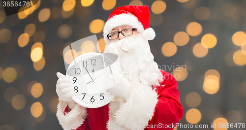 Image of man in costume of santa claus with clock