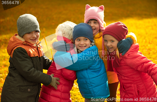 Image of group of happy children hugging in autumn park
